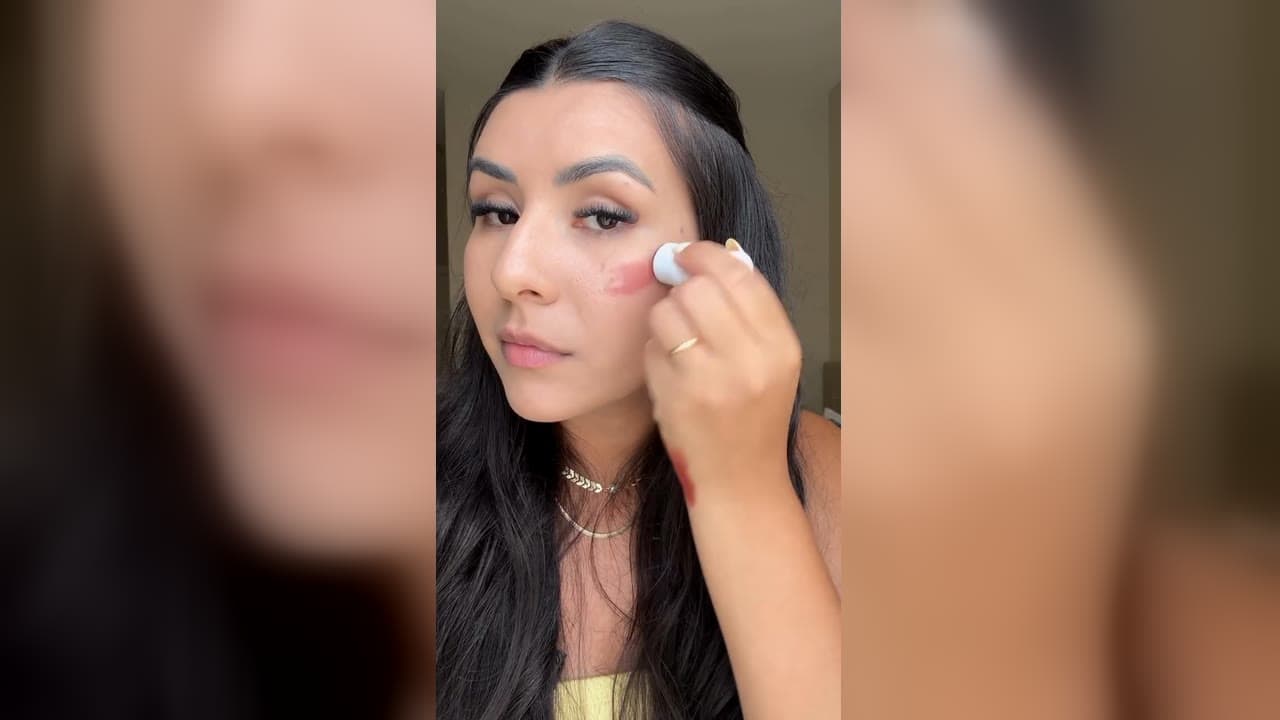 Karol Barbosa aplicando o bastão 3 em 1 da Ollie na bochecha