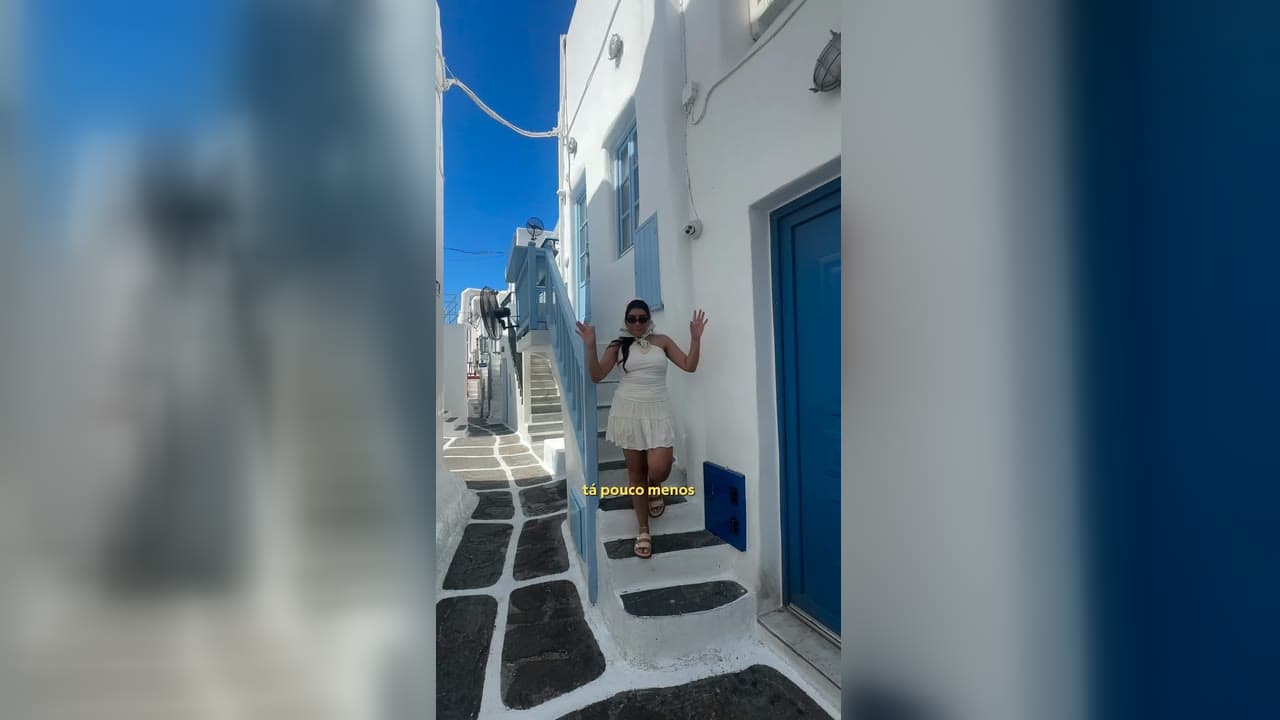 Navio de cruzeiro atracado, com as bandeiras dos países visitados na viagem