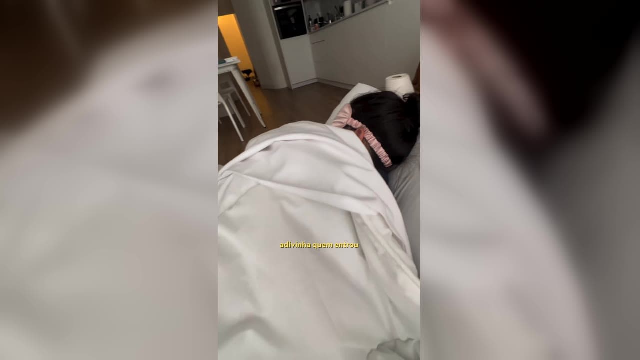 Karol Barbosa deitada embaixo do edredom, doente durante a viagem pela Europa